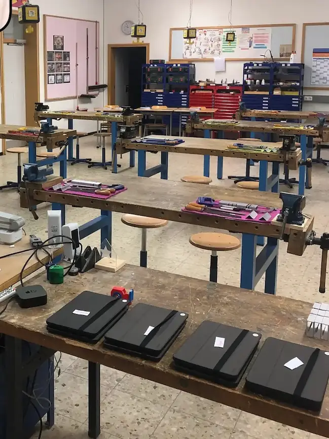Fachlehrer unterrichtet Schüler im Werkraum- Wissen vermitteln auf Augenhöhe